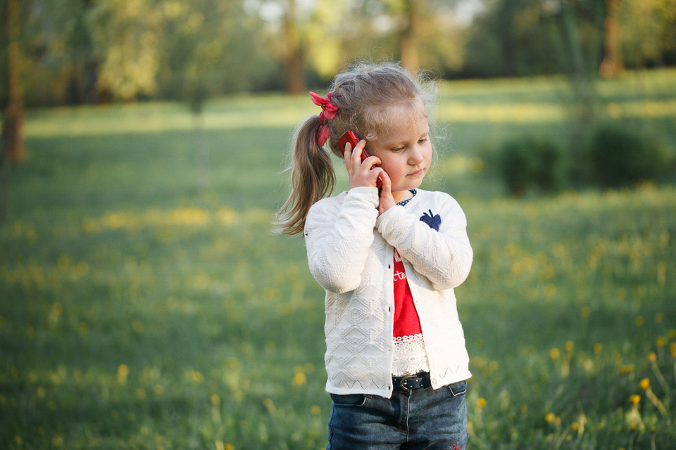Фотография ребенка, играющего с телефоном