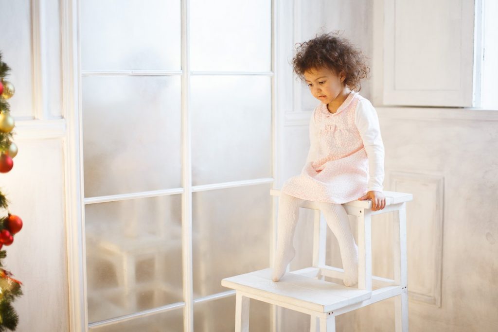 Детская фотосессия в студии - фотография ребенка на стуле