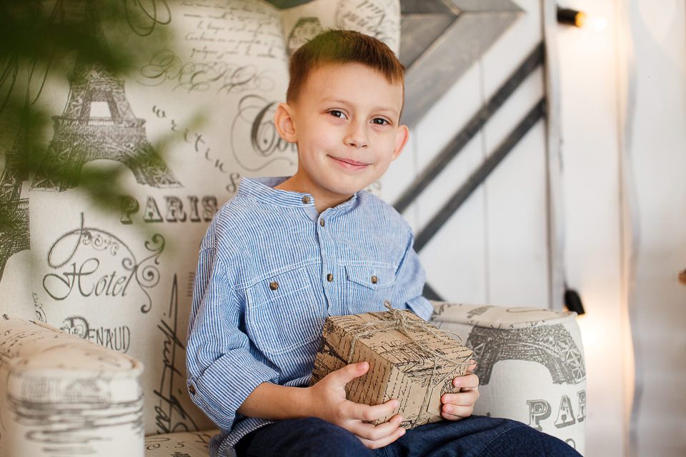 Портрет мальчика в кресле с подарком в руках